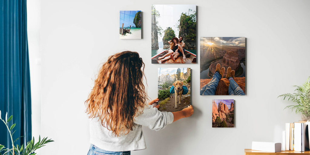 Woman hanging photo prints that feature her family, pets, and vacations.
